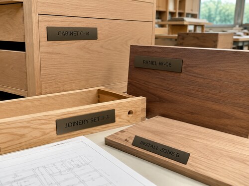 LYS-7079 matte brown black engraved cabinet panel joinery-set and installation-zone labels in a professional millwork workshop